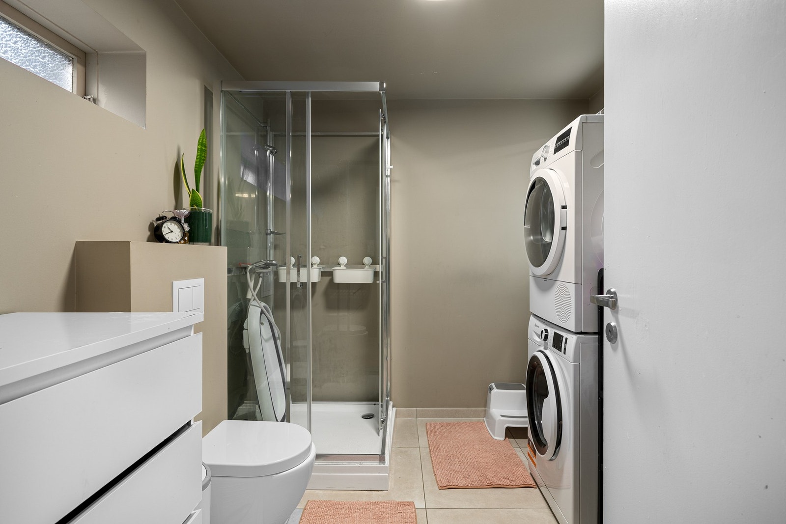 I kjelleren finner du et romslig bad med fliser på gulv, gulvvarme og vegger malt i en tidsriktig fargetone. Galleribilde