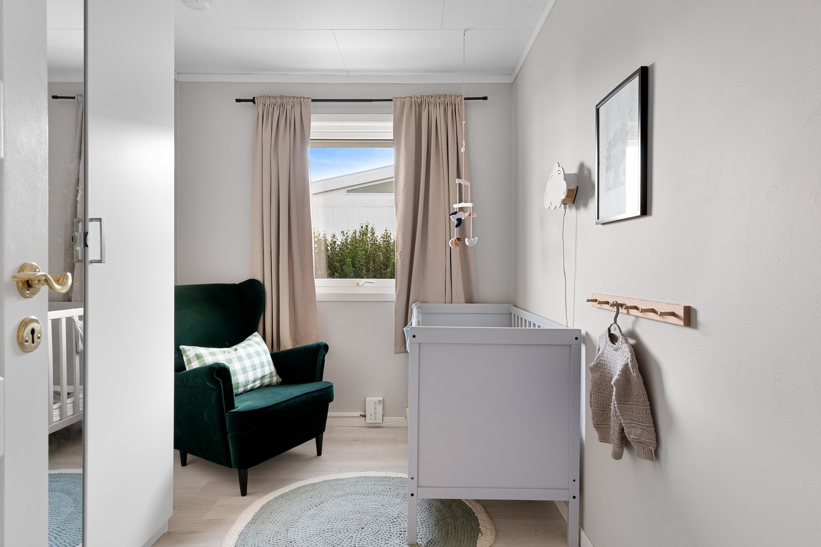 Det andre soverommet i første etasje har laminat på gulvet, beigemalte vegger og garderobeskap. Galleribilde