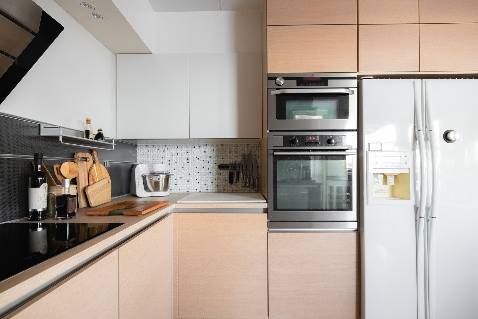 Kjøkkeninnredning fra ca. 2015 med slette fronter, heltre benkeplate og nedfelt dobbel oppvaskkum i rustfritt stål. Galleribilde