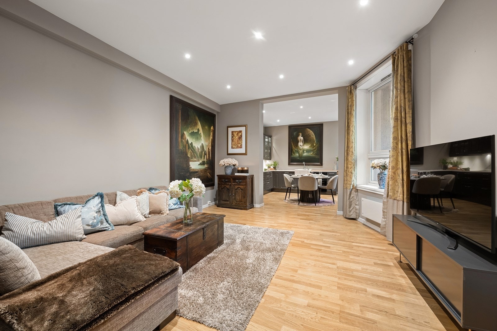 Leiligheten har en romslig og funksjonell sosial sone med delvis åpen stue- og kjøkkenløsning i rom-på-rom-utførelse Galleribilde