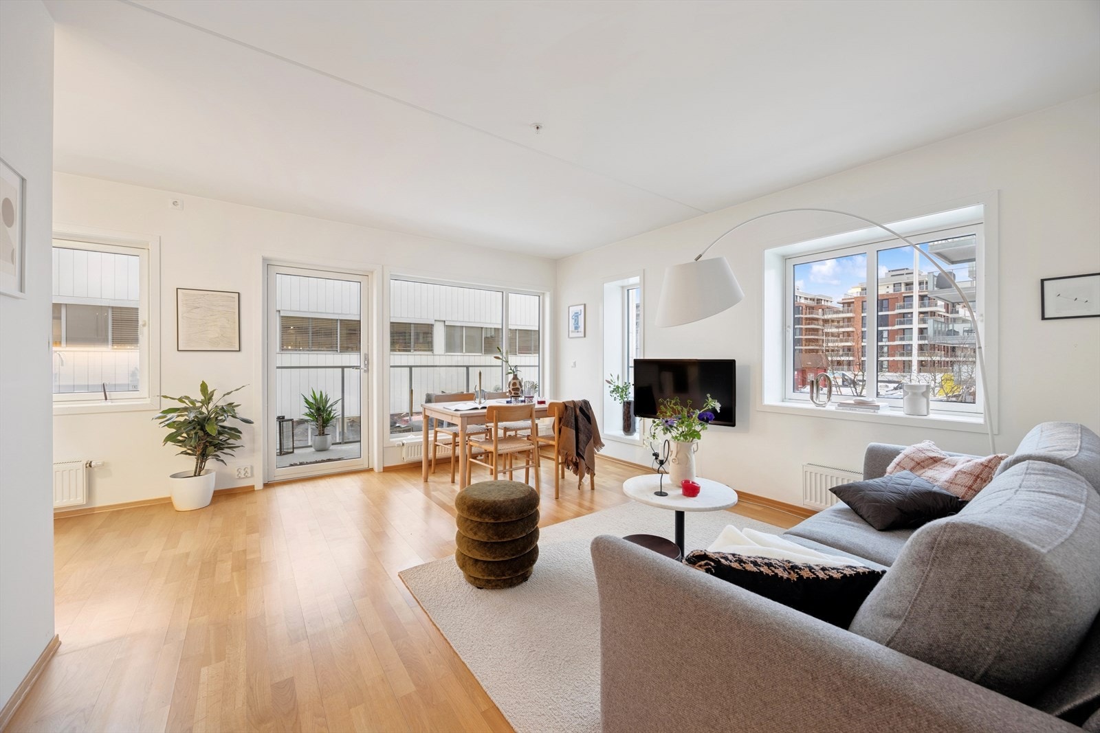 Romslig stue-/kjøkkenløsning med plass for sofagruppe og spisebord. Galleribilde