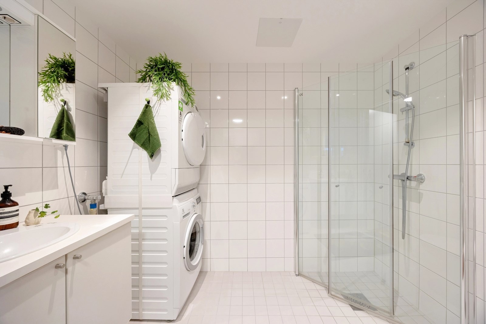 Badet holder en tidløs og fin standard med fliser på både gulv og vegger, som gir et rent og eksklusivt uttrykk. Opplegg og plass for vaskemasking og tørketrommel. Galleribilde