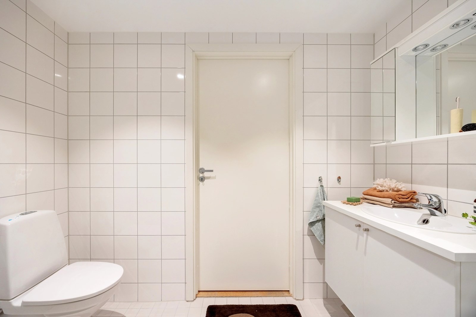 Her finner du en flott baderomsinnredning med hvitt, glatt servantskap og heldekkende servant, samt overskap med speildel som gir rommet en lys og luftig følelse. Galleribilde