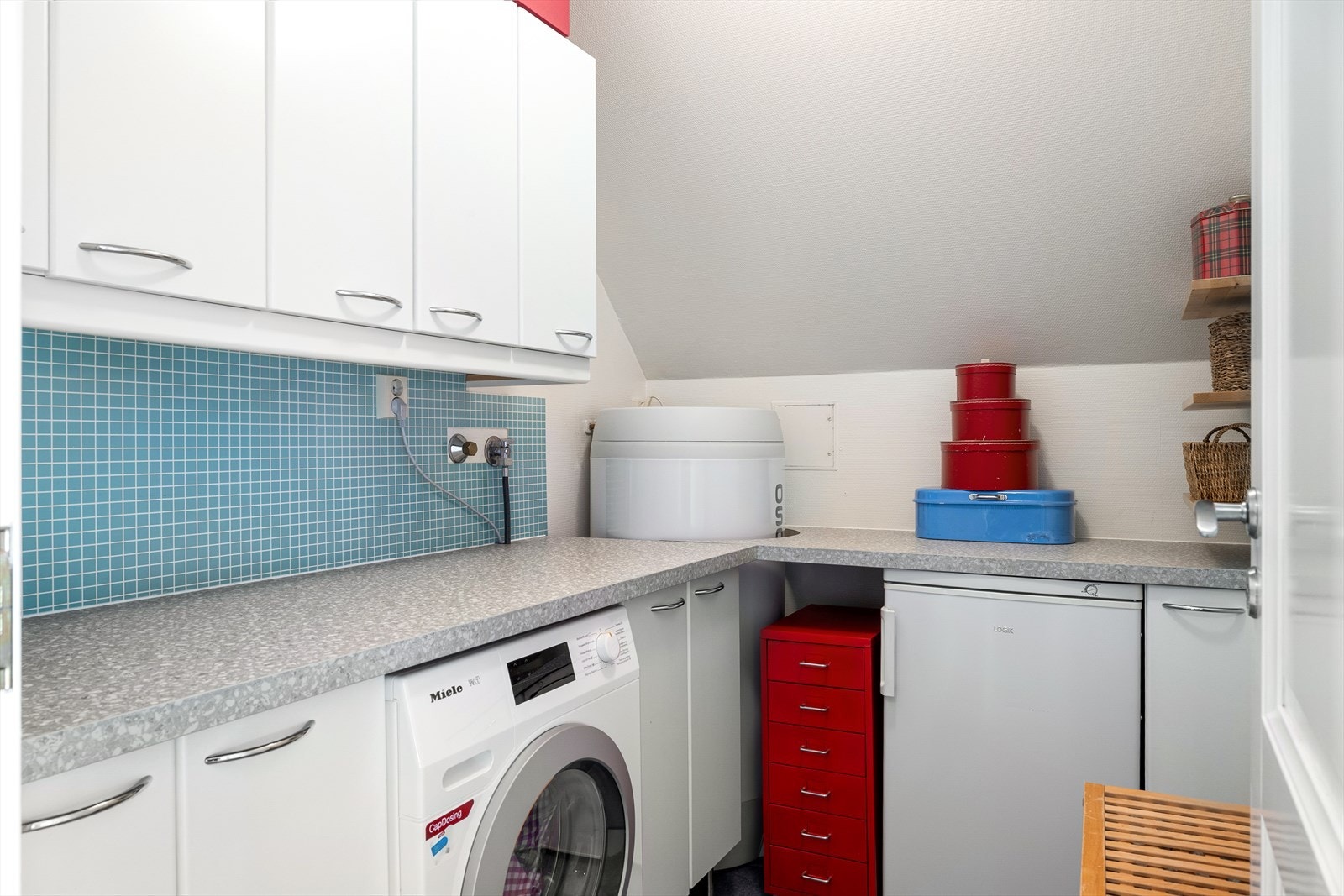 Vaskerommet er fra byggeår og gir praktiske løsninger for klesvask og oppbevaring. Galleribilde