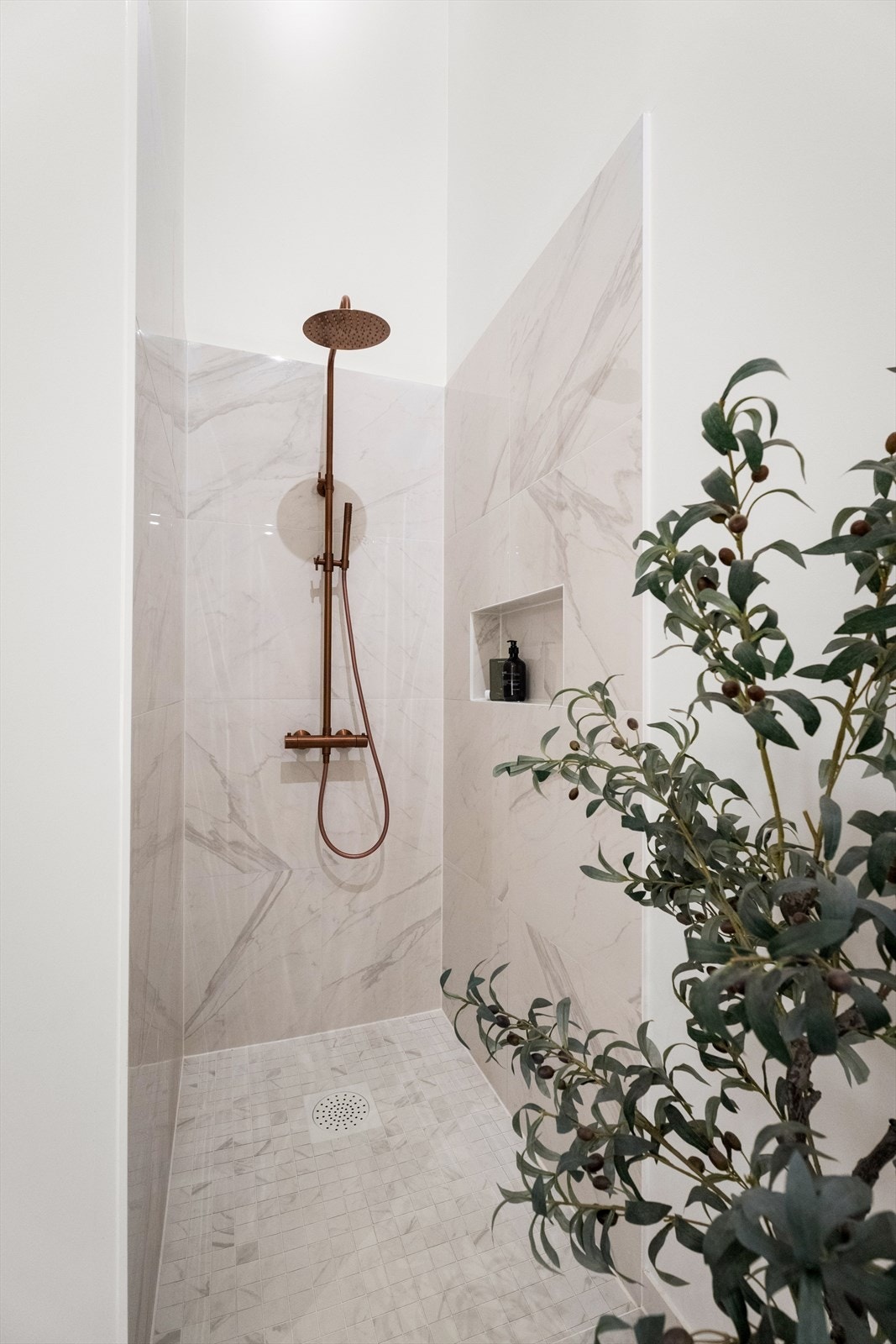 Dusjnisje med integrert, plassbygd hylle som gir praktisk og elegant oppbevaring av dusjartikler. Galleribilde