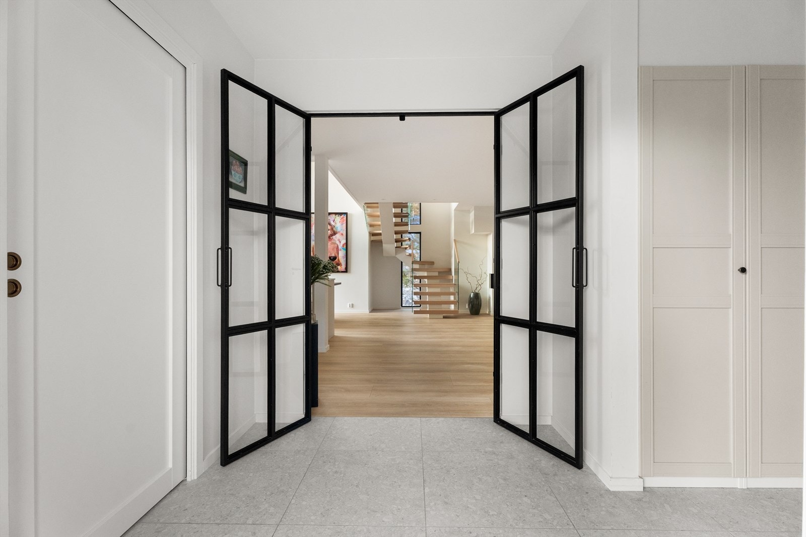 Elegant gjennomgang med to-fløyet dør mellom entré og stue/kjøkken i boligens 1. etasje. Galleribilde