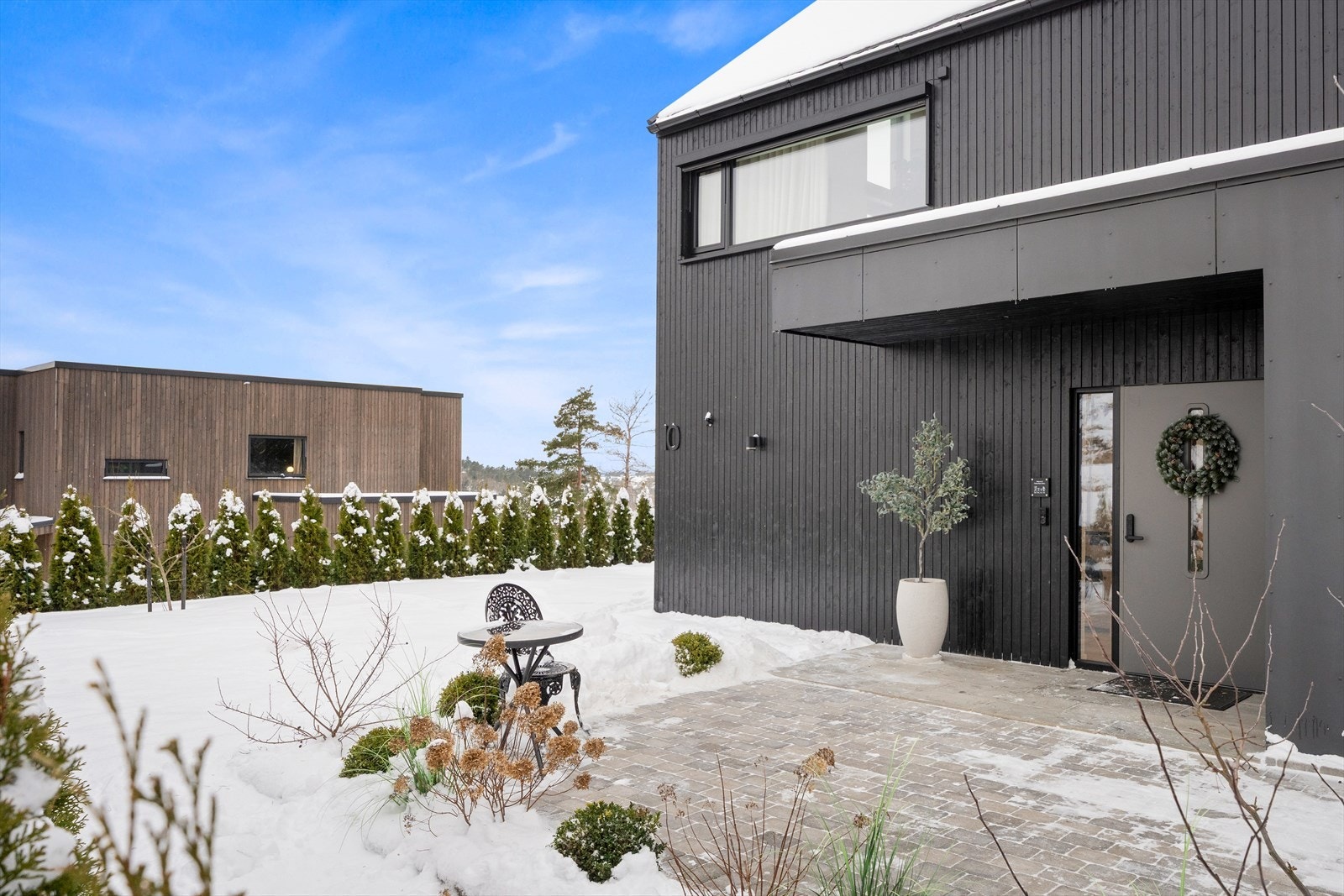 Takoverbygd inngangsparti og gårdsplass opparbeidet med belegningsstein. Galleribilde