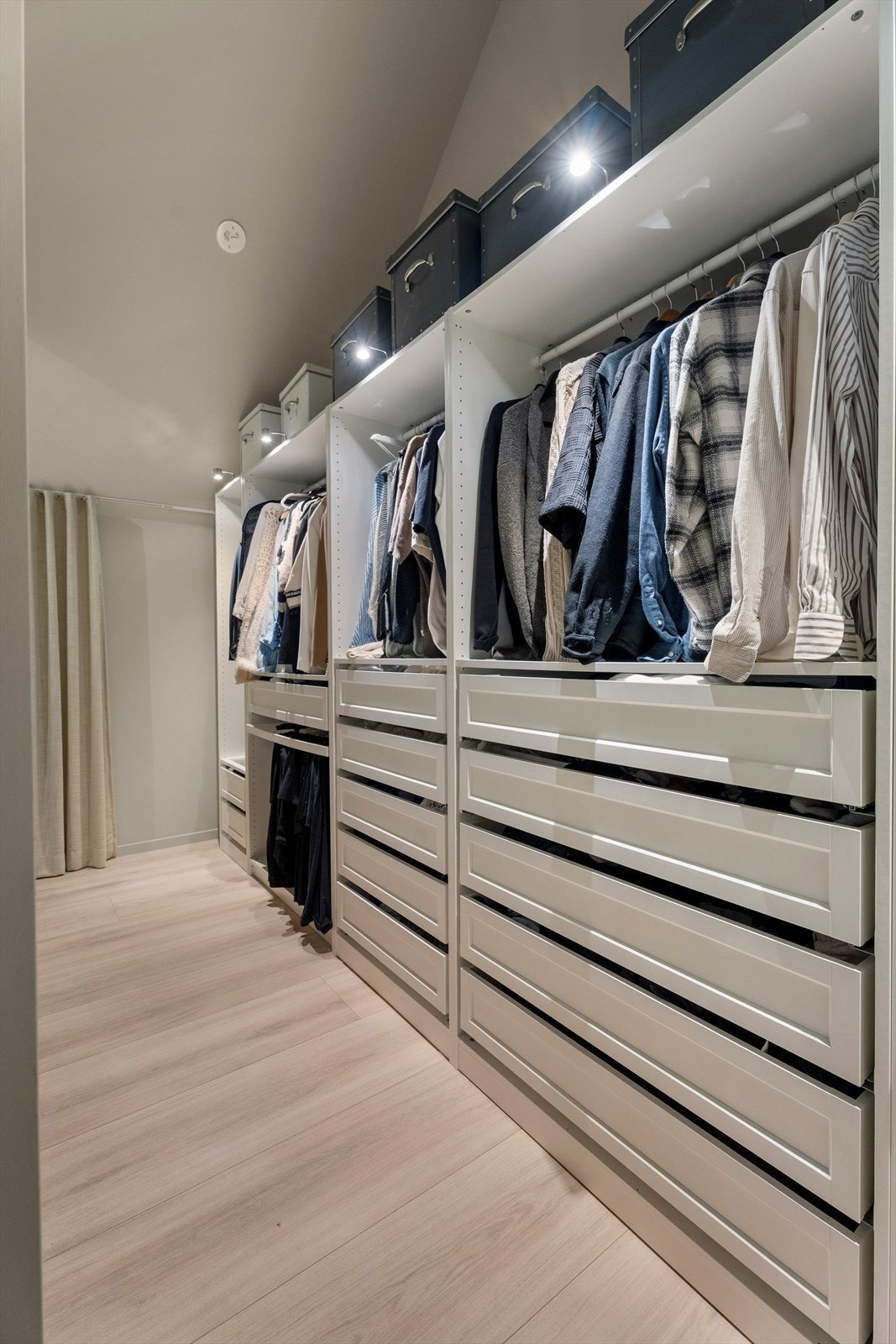 Rommet har også en egen omkledningsdel med åpen garderobeløsning, avskjermet med en diskré skillevegg som skaper en tydelig soneinndeling uten å ta unødvendig plass. Galleribilde