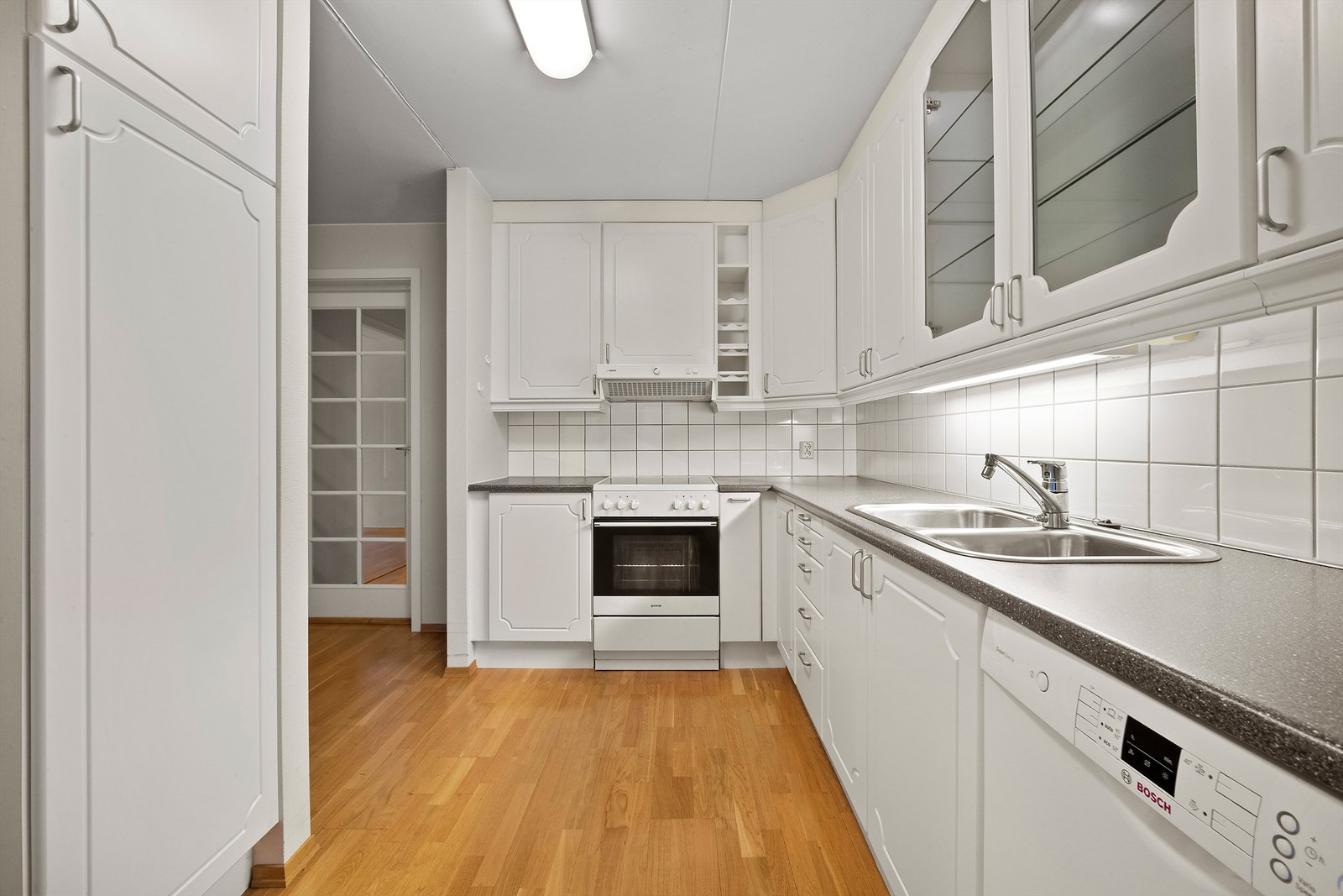 Kjøkkenet har hvite, profilerte fronter med matchende overskap og laminat benkeplate. Galleribilde