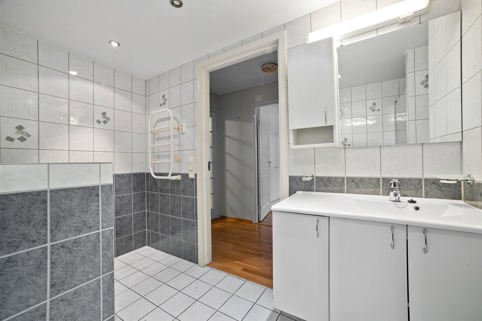 Baderom fra byggeår med flislagte overflater og gulvvarme. Galleribilde