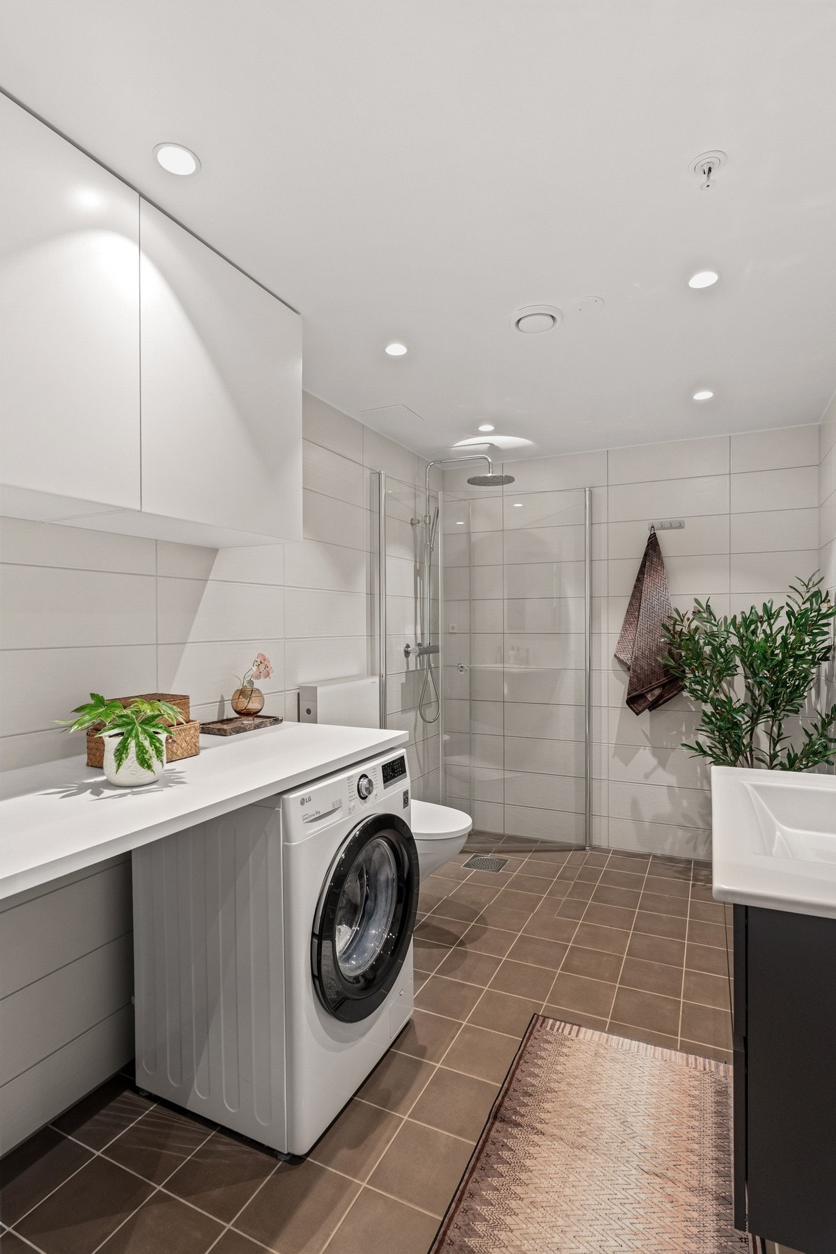 Det er opplegg for vaskemaskin og tørketrommel under veggskap og benkeplate. Galleribilde