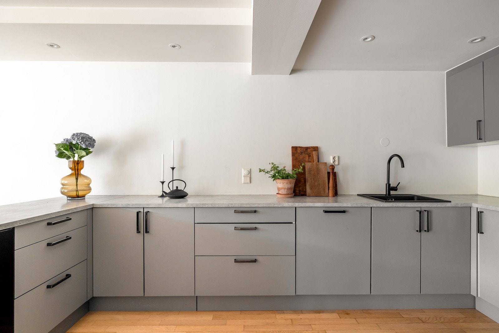 Kjøkkeninnredningen fra HTH har glatte, grå fronter og laminat benkeplate med nedfelt kum i kompositt Galleribilde