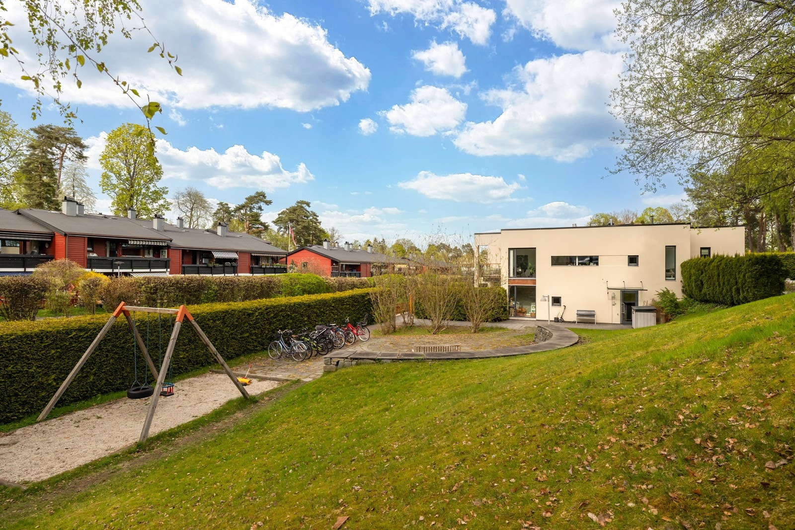 Fellesområdene er pent opparbeidet med sittegruppe, lekeplass og felles sykkelparkering Galleribilde