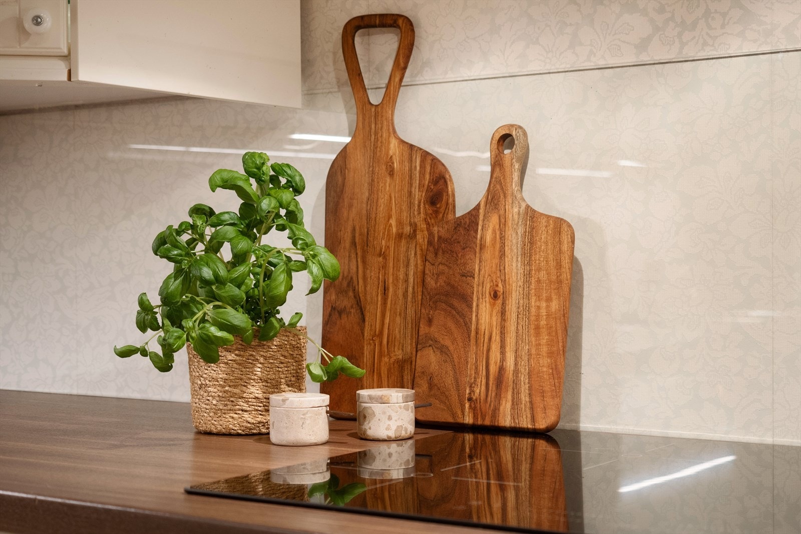 Praktisk veggbeskyttelse mellom benkeplate og overskap, samt kjøkkenventilator over kokesonen. Galleribilde