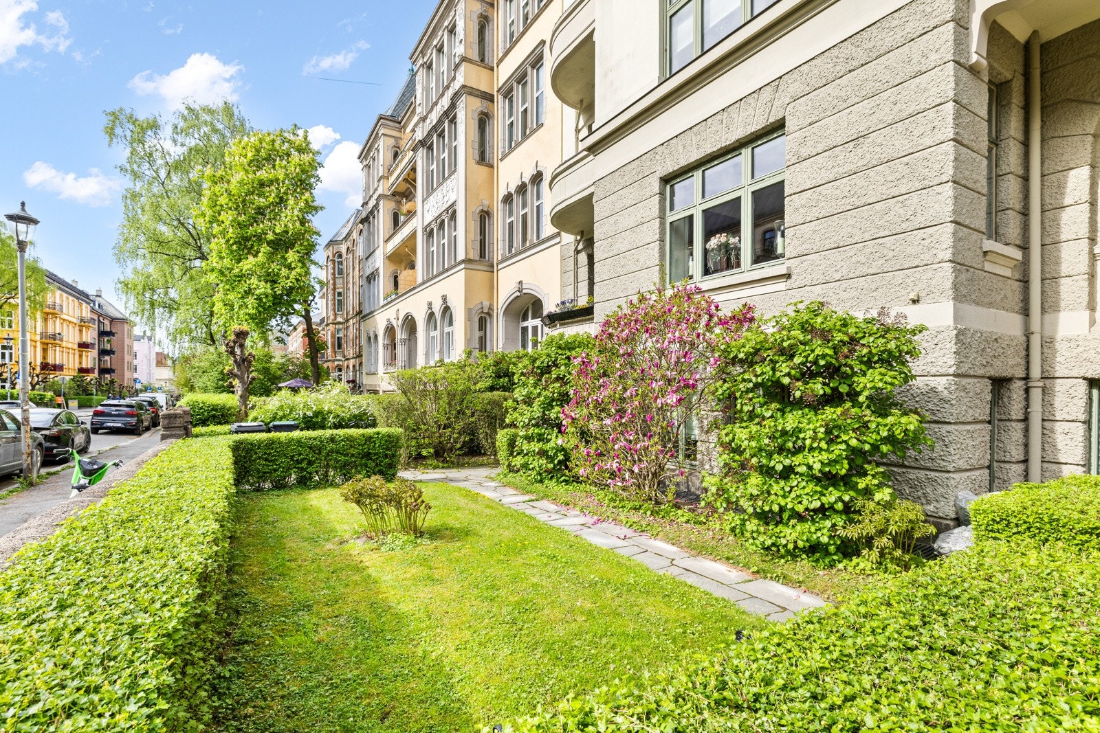 Et fredfullt uteområde med sittegrupper og frodig beplantning. Galleribilde