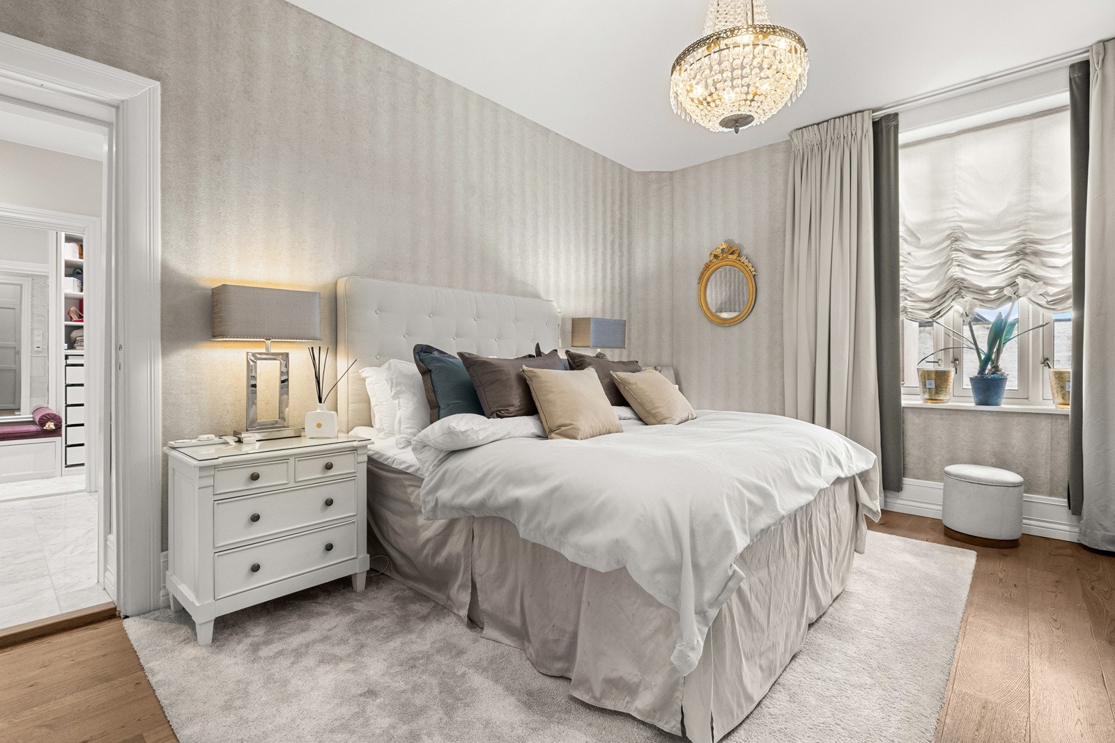 Gulvet i varm parkett og tunge, elegante gardiner skaper en harmonisk helhet - et rom hvor ro og komfort står i sentrum. Galleribilde