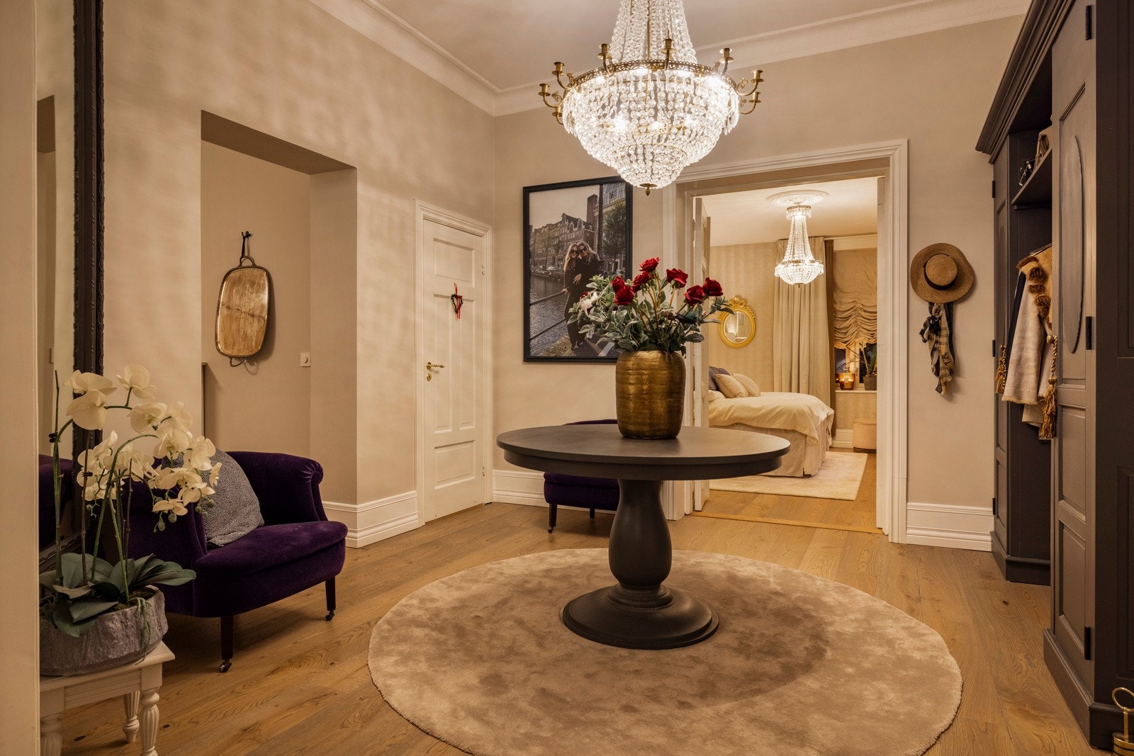 Kveldens lys spiller elegant i den store krystallysekronen og speiler seg i de klassiske overflatene - en velkomst som oser av kvalitet. Galleribilde