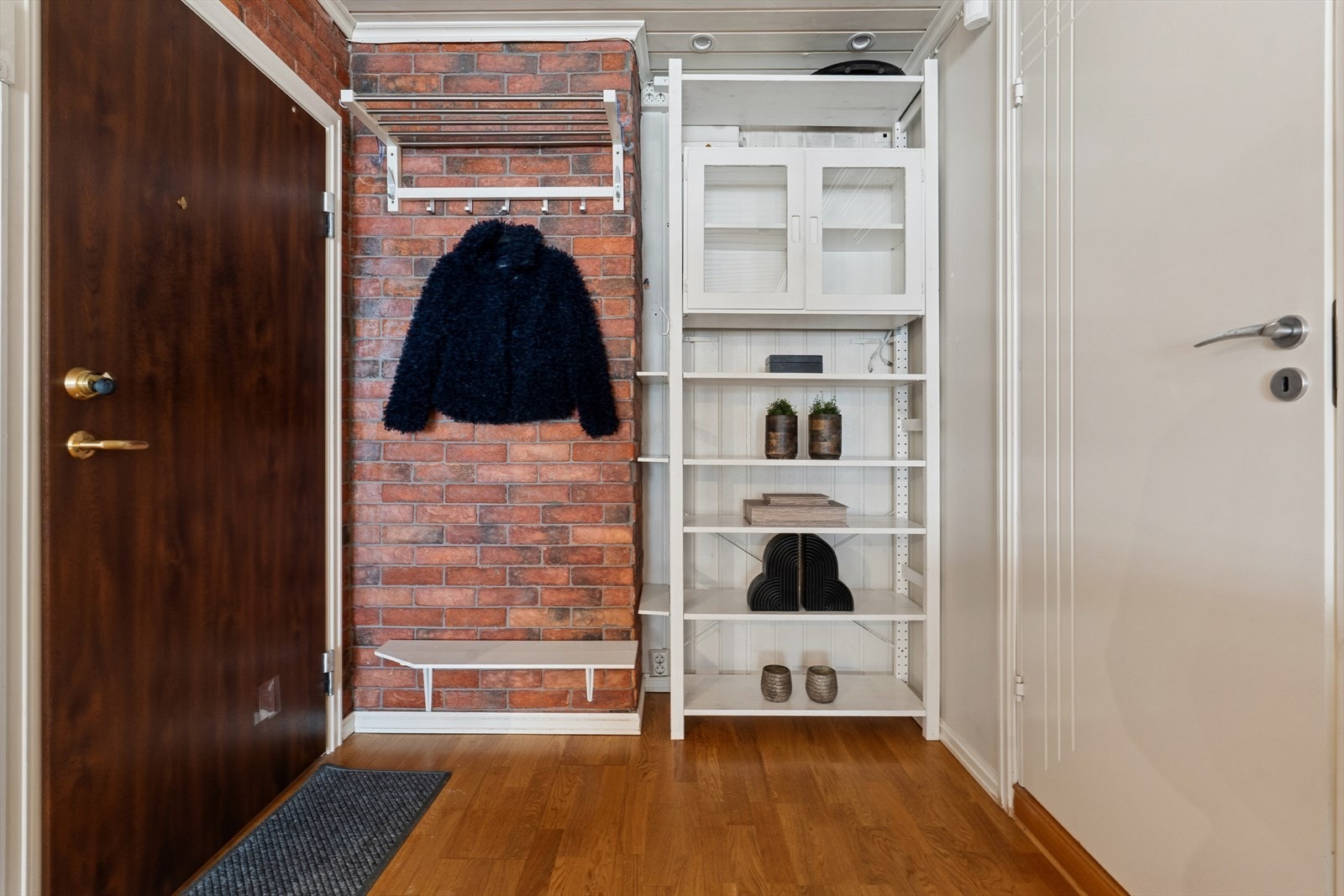 Teglsteinsvegger og praktiske oppbevaringsløsninger i entréen setter tonen for resten av boligen. Galleribilde