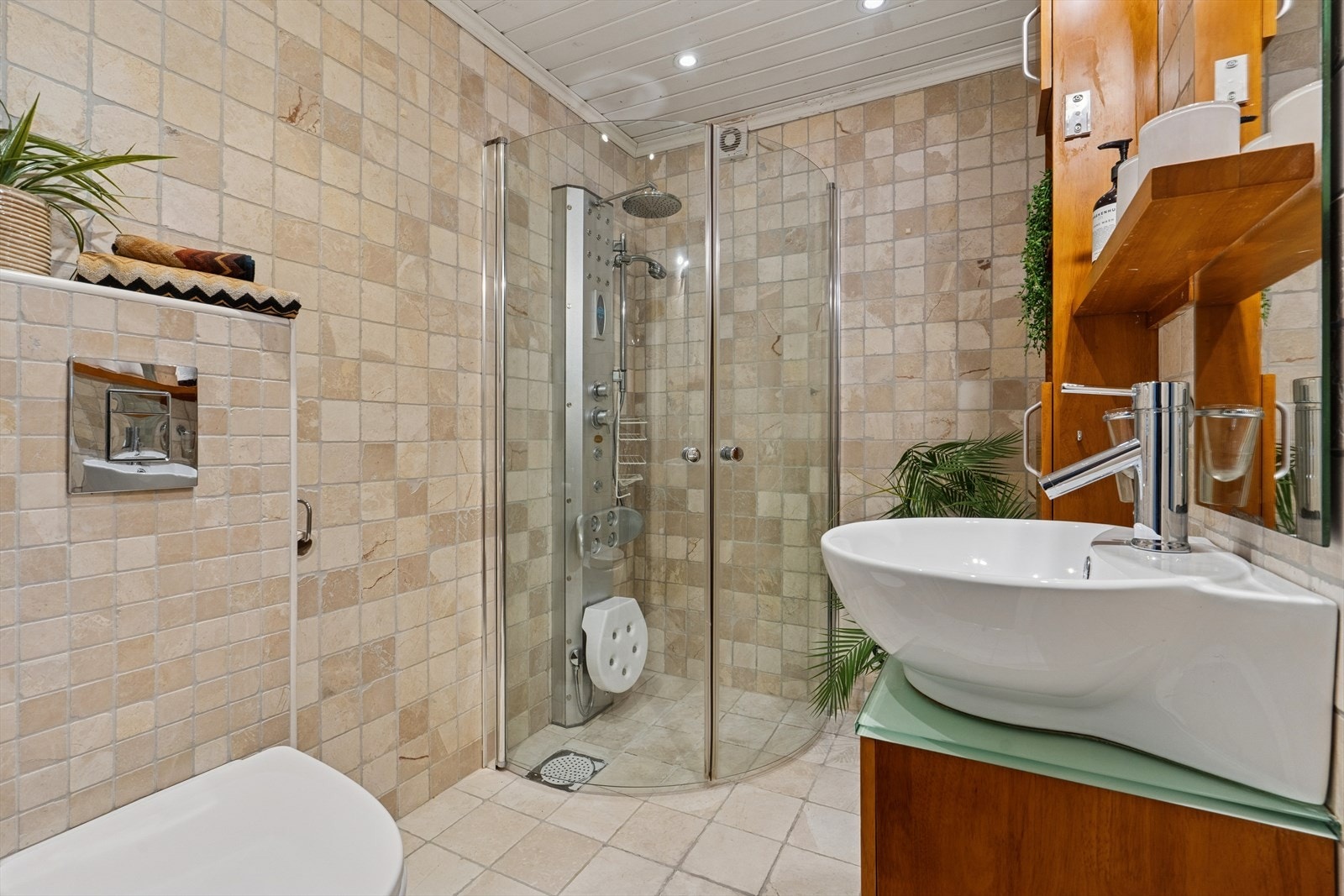 Badet har vegghengt toalett, massasjedusjarmatur og opplegg for vaskemaskin. Galleribilde