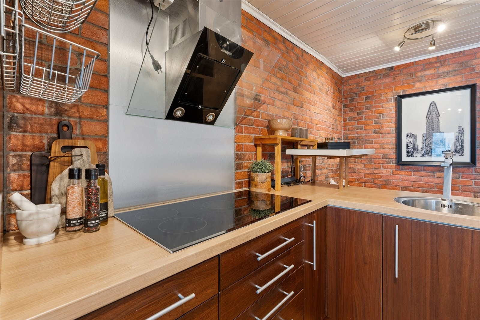 Innredningen har slette, finerte fronter og ventilator med kullfilter over kokesonen. Galleribilde