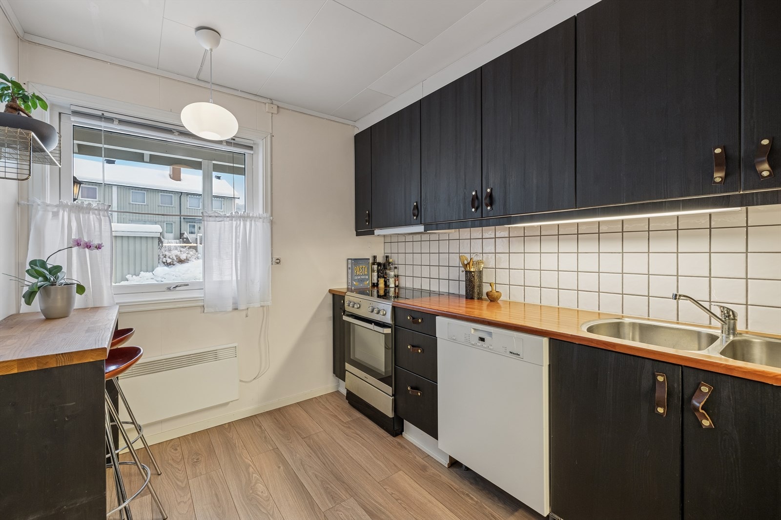 Over benkeplaten er det montert fliser og belysning under overskapene. Galleribilde