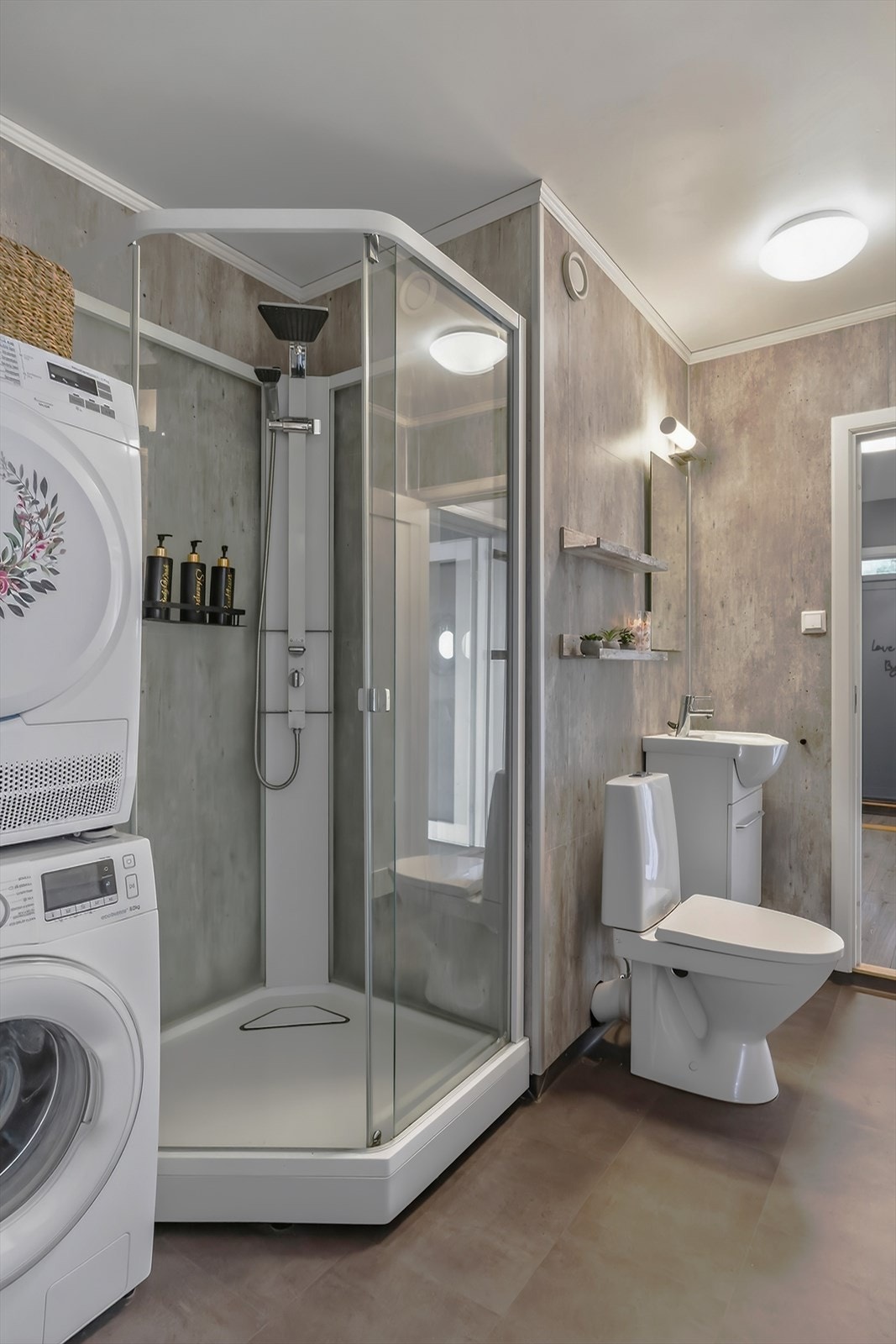 Innbydende bad fra 2015 med vinylbelegg og gråtonet baderomsplater på vegg. Galleribilde