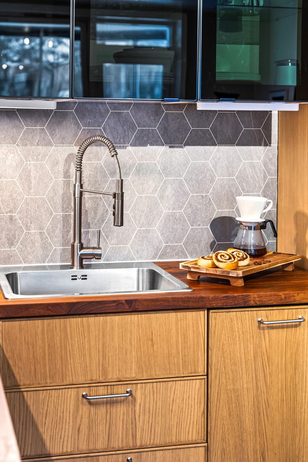 Benkeplaten i finert plate og flislignende plater over benken gir kjøkkenet et stilrent preg. Galleribilde