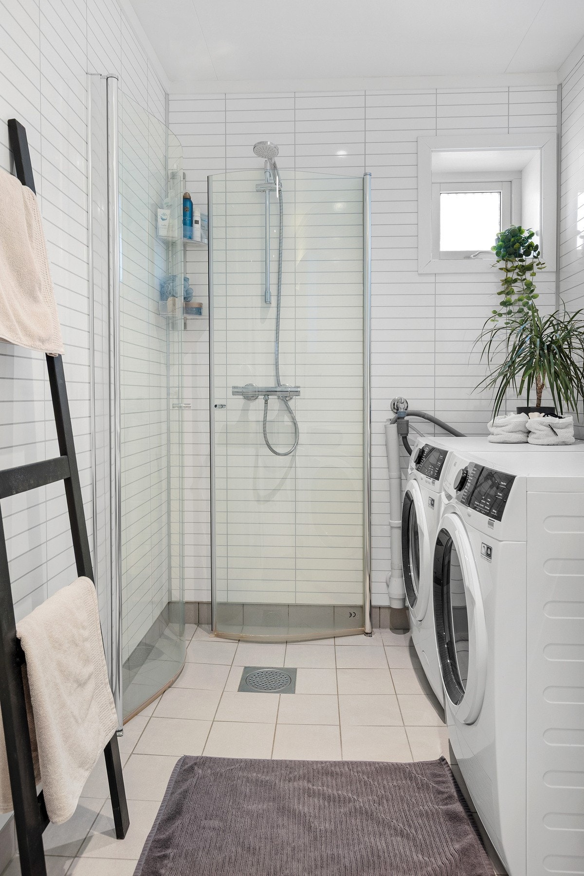 Bad med romslig dusjhjørne og glassvegger Praktisk løsning med dusj og vaskemaskin Galleribilde