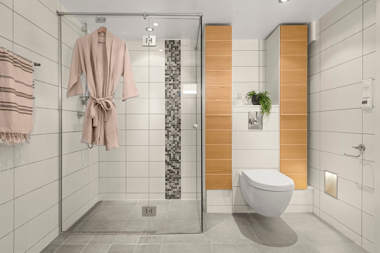 Flislagt gulv med elektriske varmekabler og himlingen med downlights som gir et behagelig lys. Galleribilde