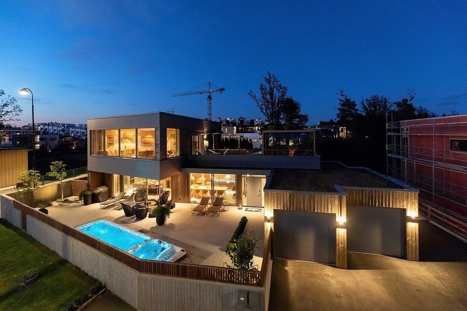 Bilde av huset sett fra gaten. Parkering på bakkeplan, inngang til leilighet er til høyre og ned en trapp her. Galleribilde