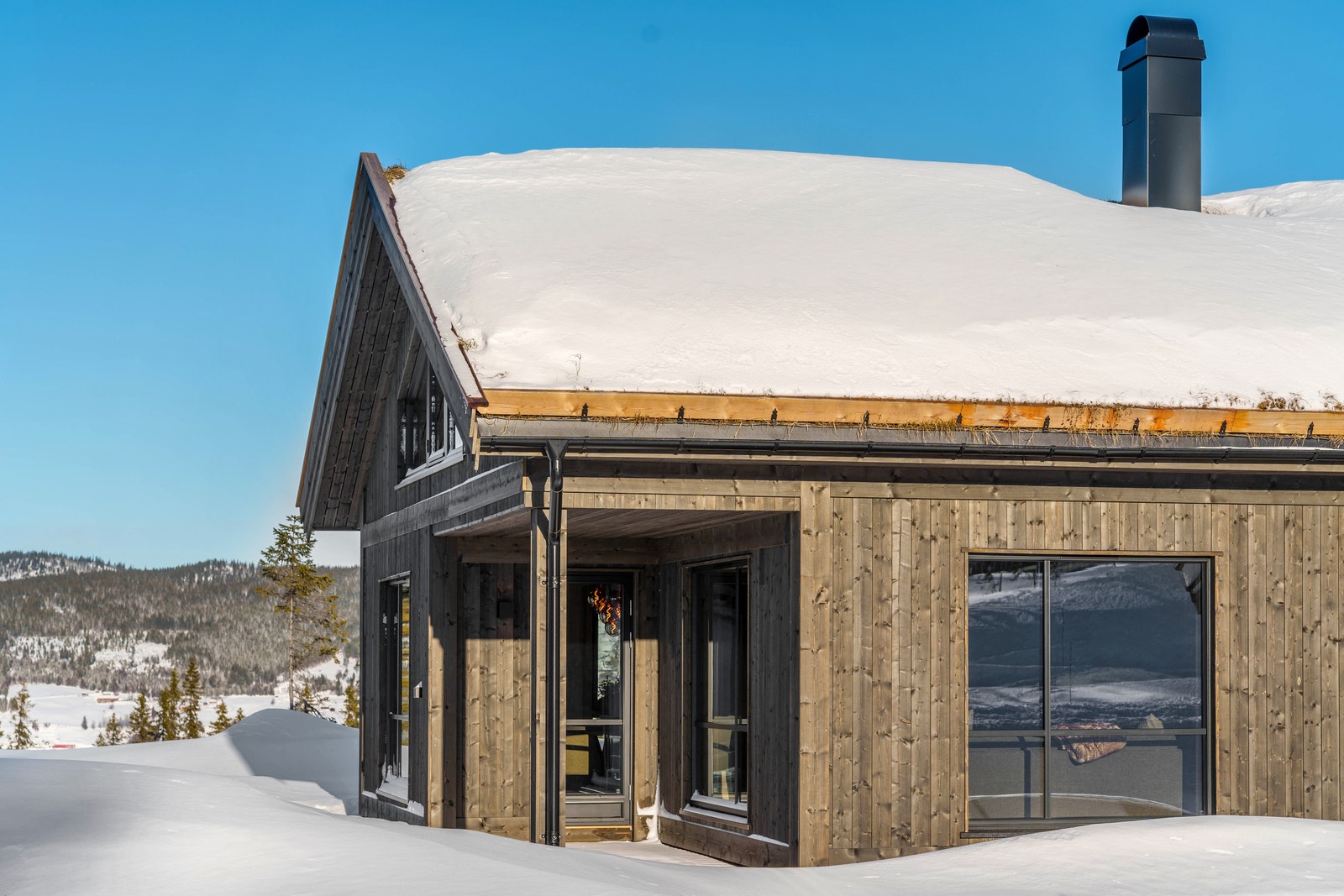 Hytta har delvis overbygget terrasse for lune stunder i solveggen Galleribilde