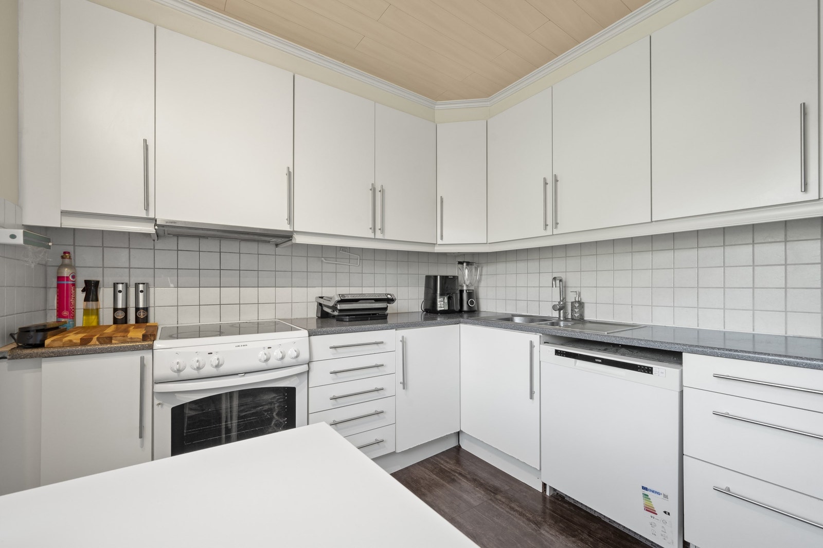 Innredningen har slette fronter og laminert benkeplate med nedsenket oppvaskkum i metall Galleribilde