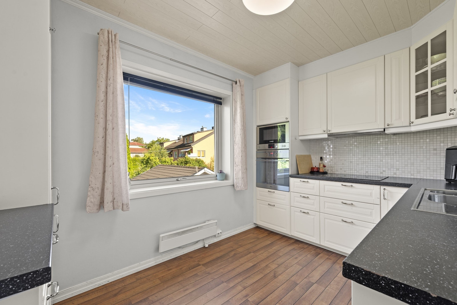 Praktisk kjøkken med klassiske profilerte fronter kombinert med laminert benkeplate Galleribilde