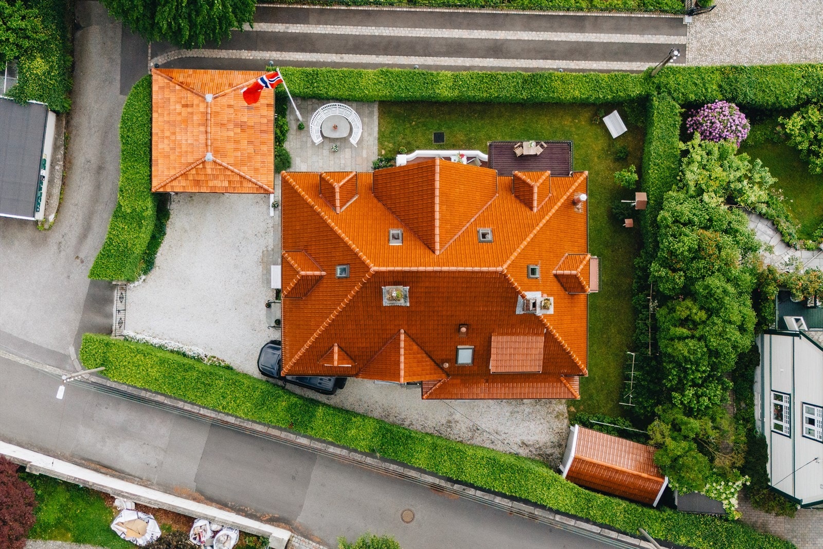 - Tomten er elegant innrammet av hekker og smijernsporten - Galleribilde