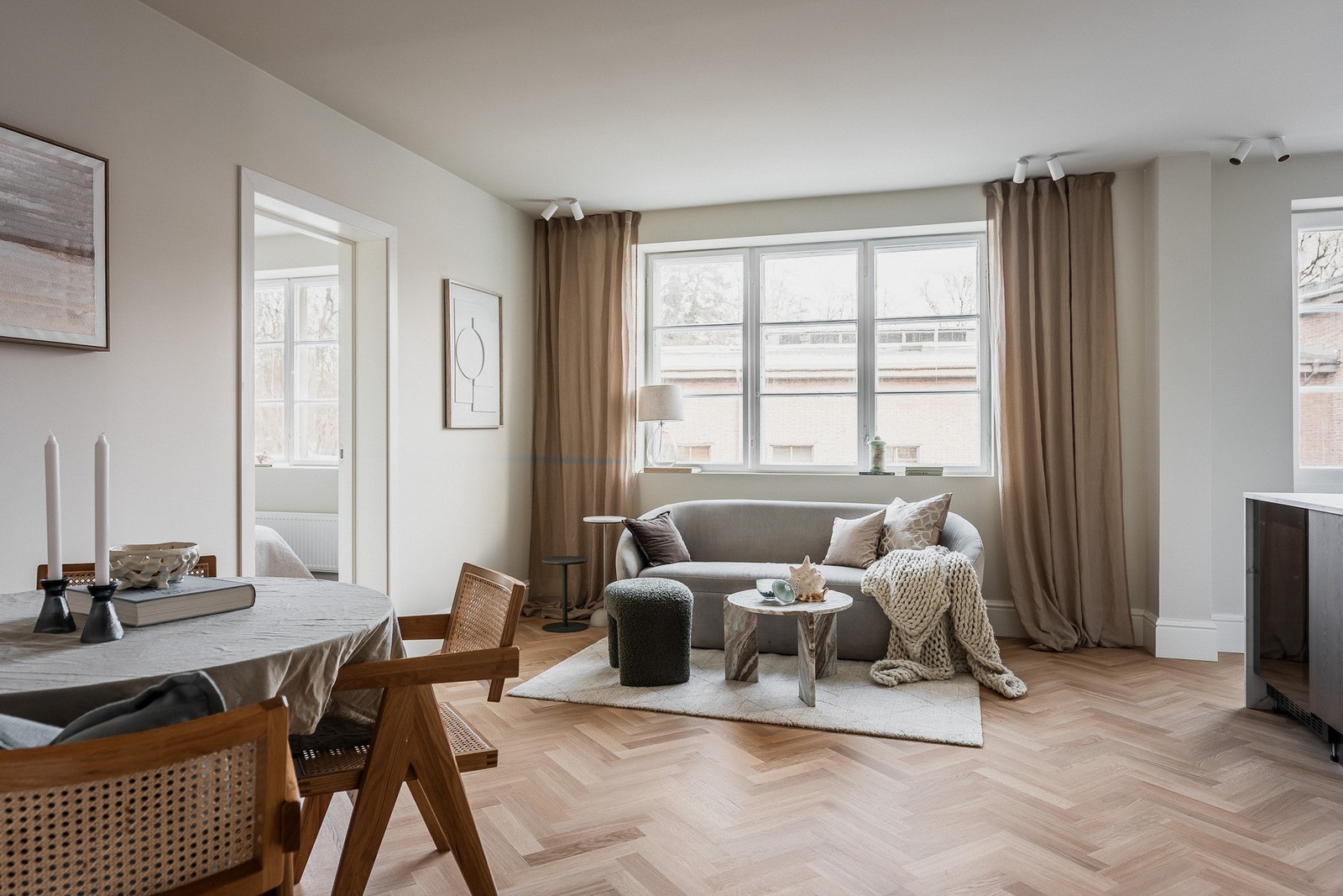 Lyst oppholdsrom med eksklusiv fiskebensparkett og store vindusflater som fyller rommet med naturlig lys. Galleribilde