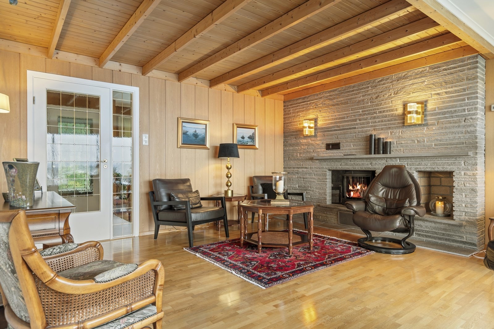 Koselig stue med parkett på gulv, tapet på vegger. Peisovn, varmepumpe. Galleribilde