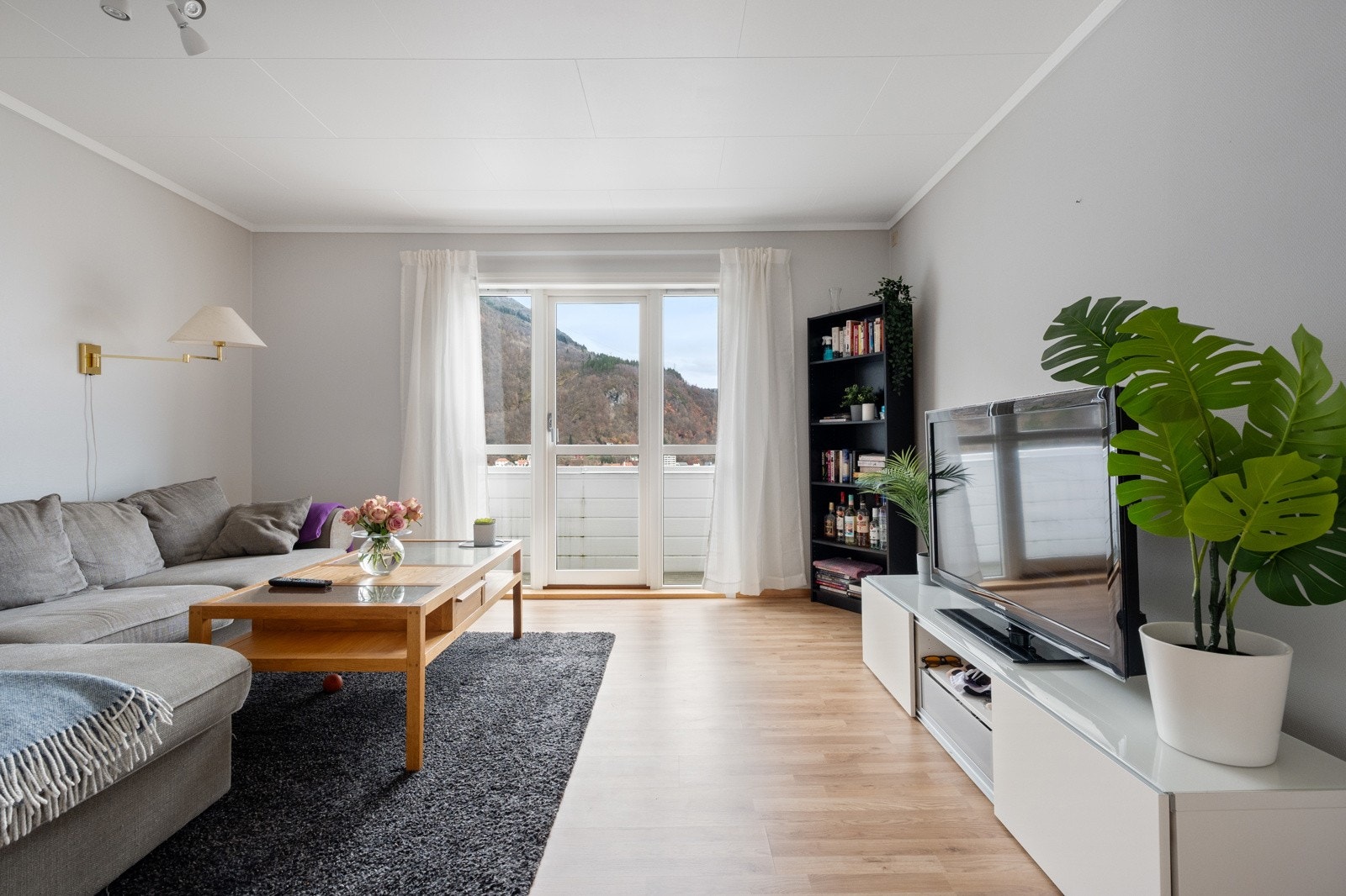 Romslig stue med utgang til en sørvendt balkong Galleribilde