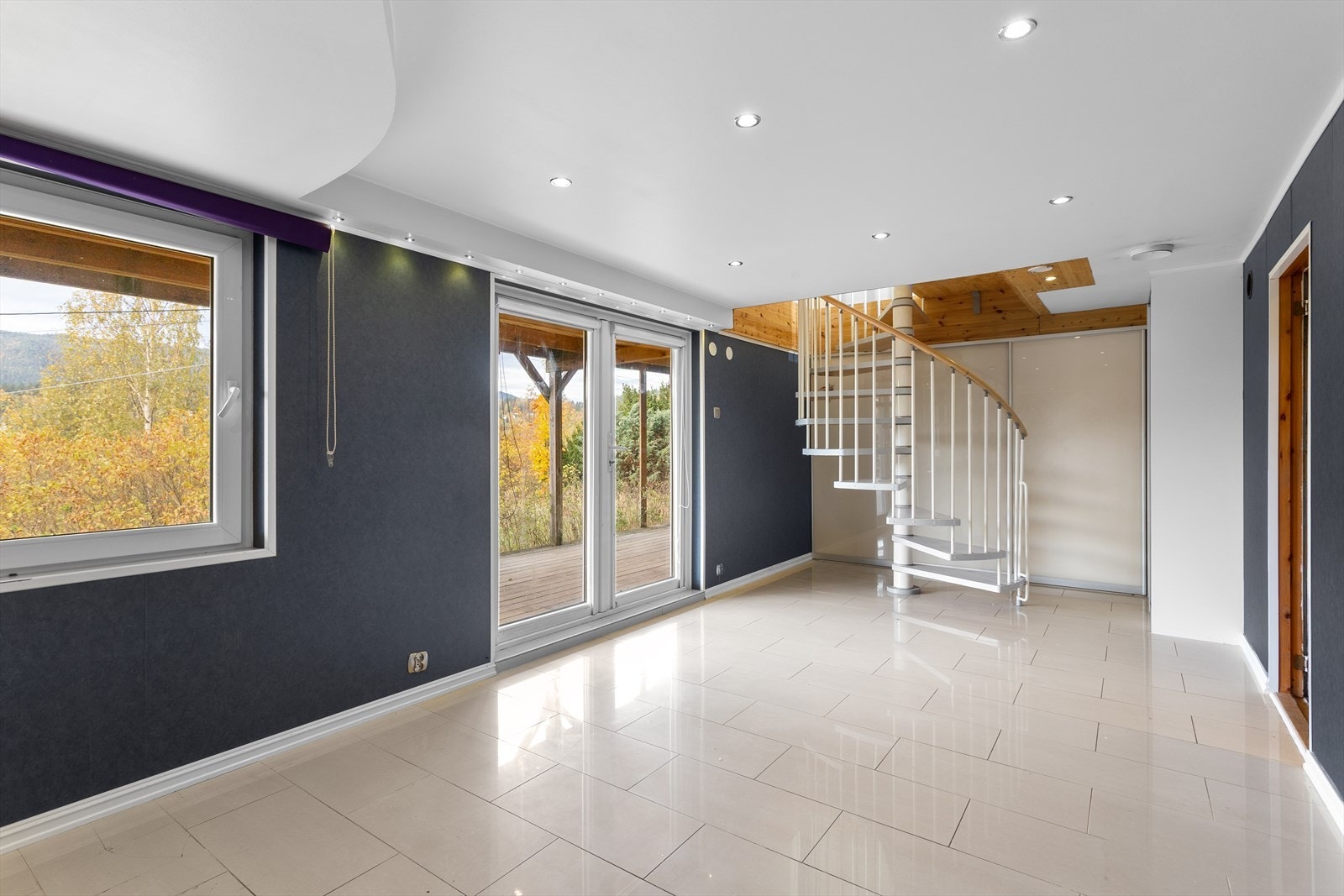 Trappen leder deg ned til underetasjen med fliser på gulv og tapet på vegger. Galleribilde