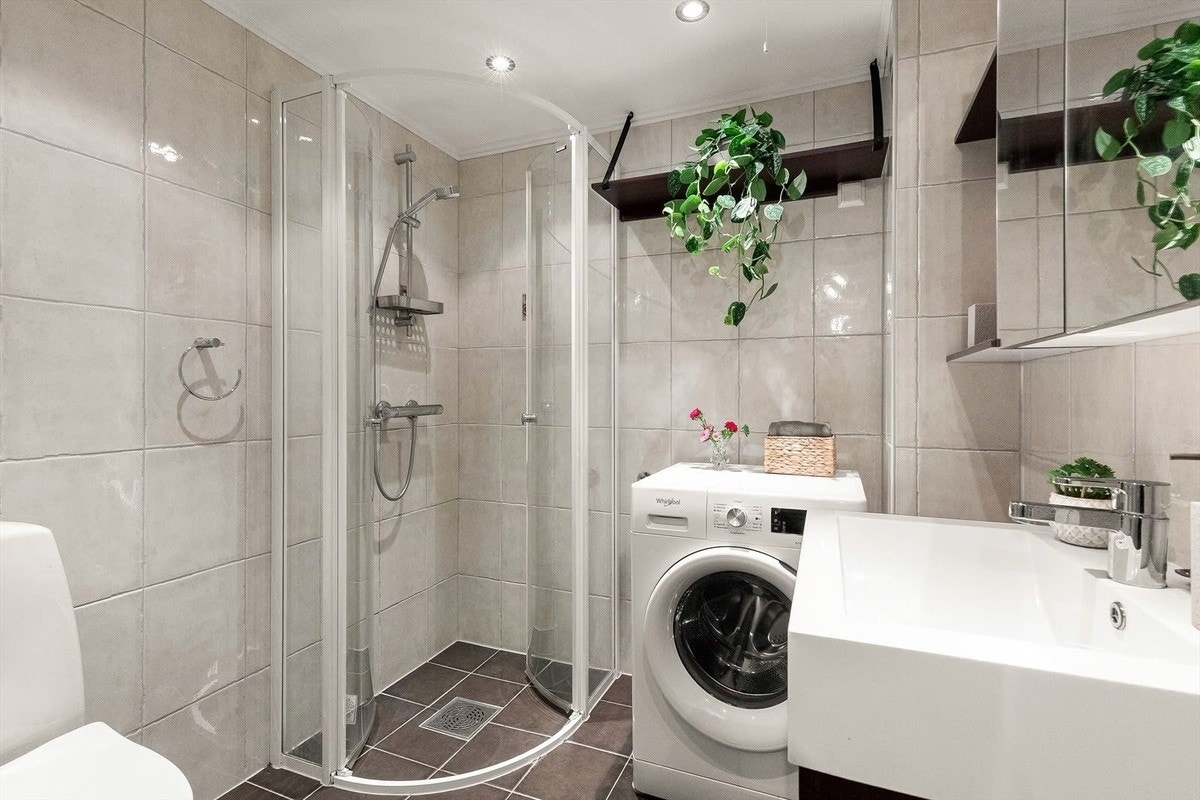 Flislagt bad med regnfallsdusj, vaskemaskin og varmekabler i gulv. Galleribilde