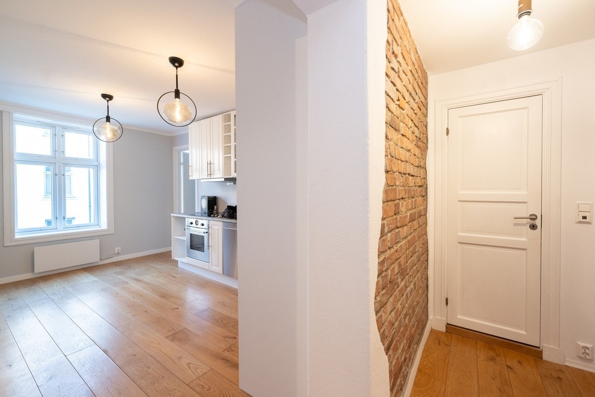 Åpen stue- og kjøkkenløsning med originale murvegger. Galleribilde