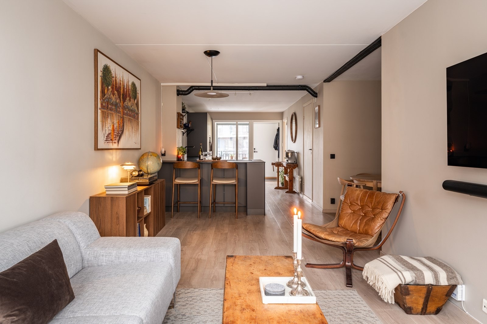 Den åpne løsningen mellom stuen og kjøkkenet gjør dette til et hyggelig og sosialt oppholdsrom. Galleribilde