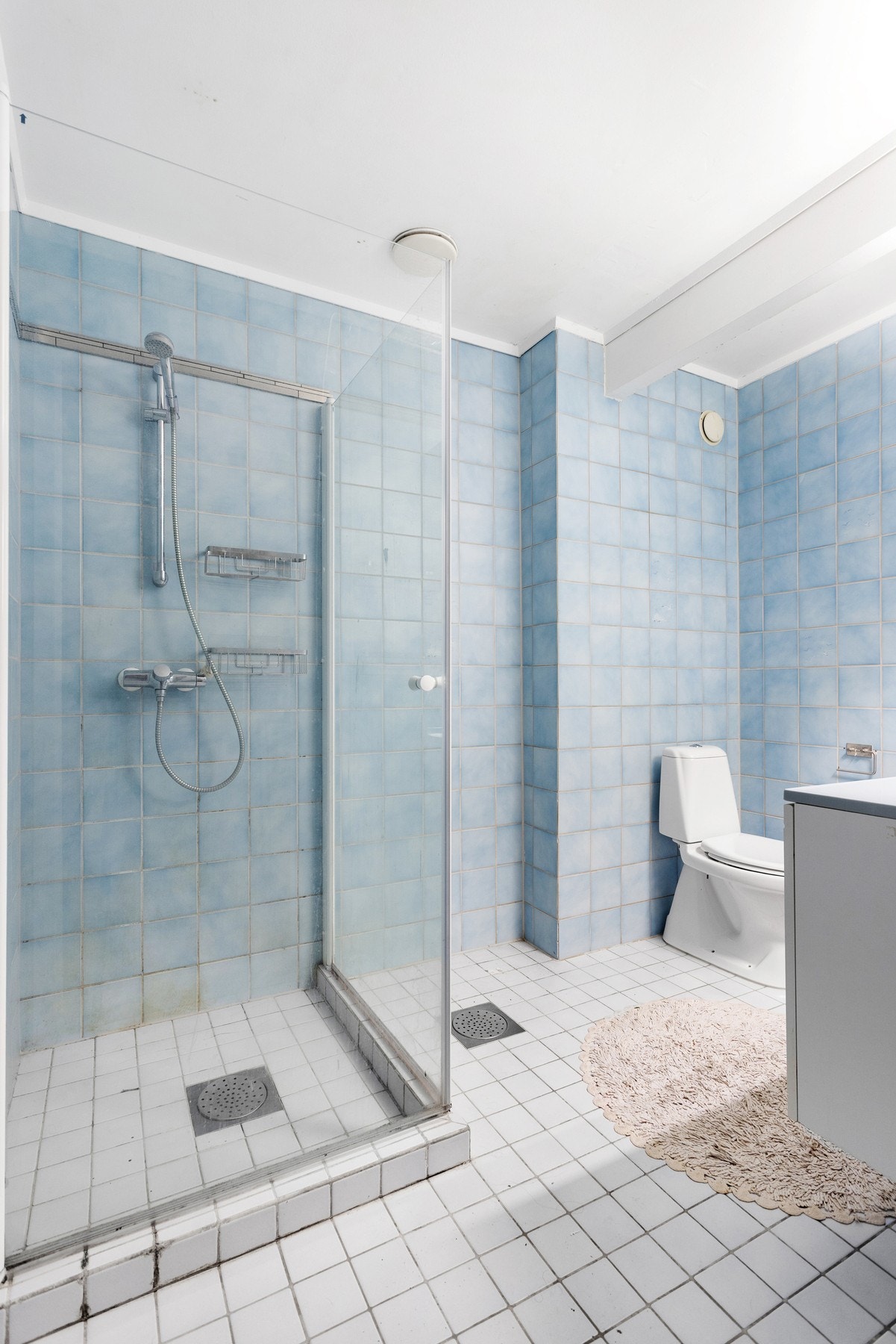 Flislagt bad som er innredet med toalett, dusjnisje og baderomsinnrending med servant. Galleribilde