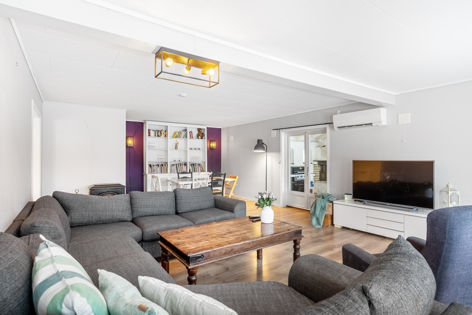 En stue med plass til langbord, sofakos og kort vei til ekstra hygge i vinterhage Galleribilde