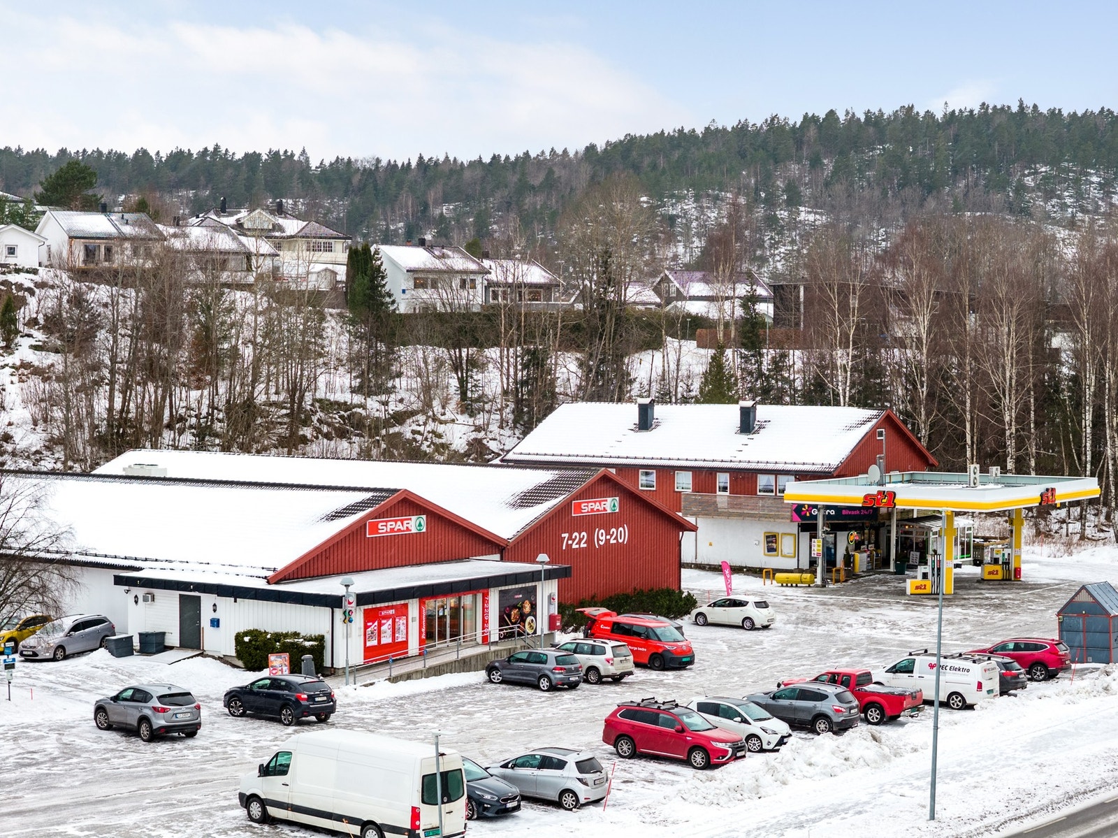 Nærbutikken Spar i Kodal sentrum med bensinstasjon og buss på samme område Galleribilde