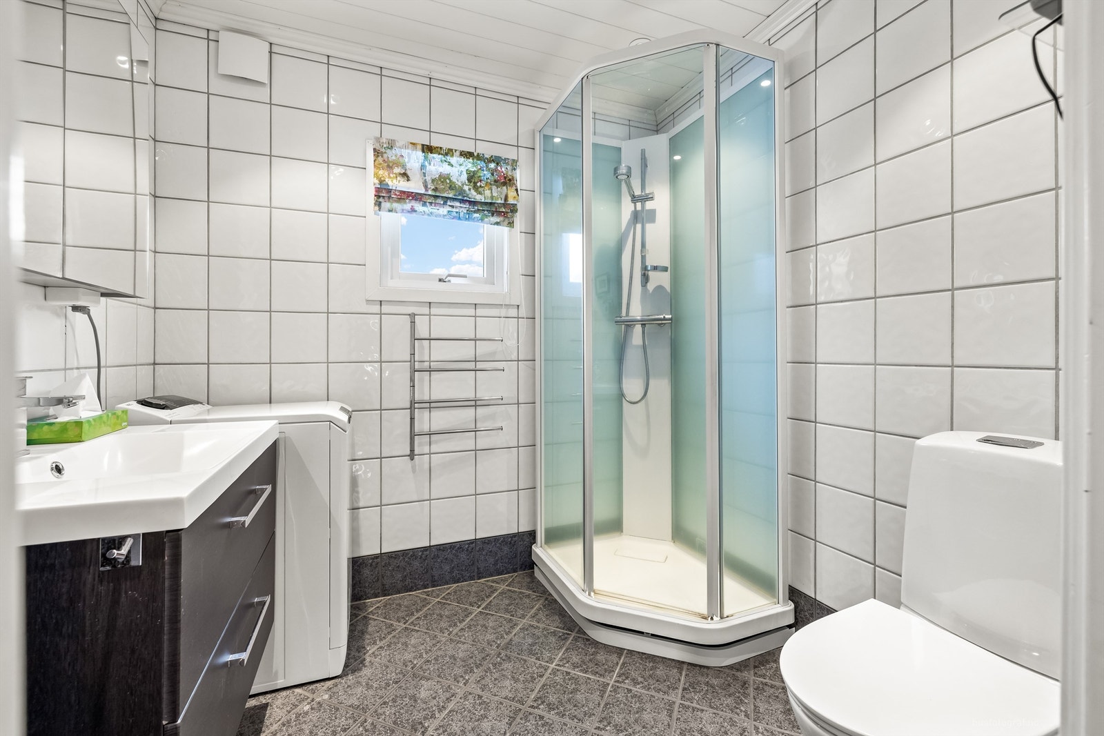 Rommet er utstyrt med dusjkabinett, servantskap og opplegg for vaskemaskin. Galleribilde