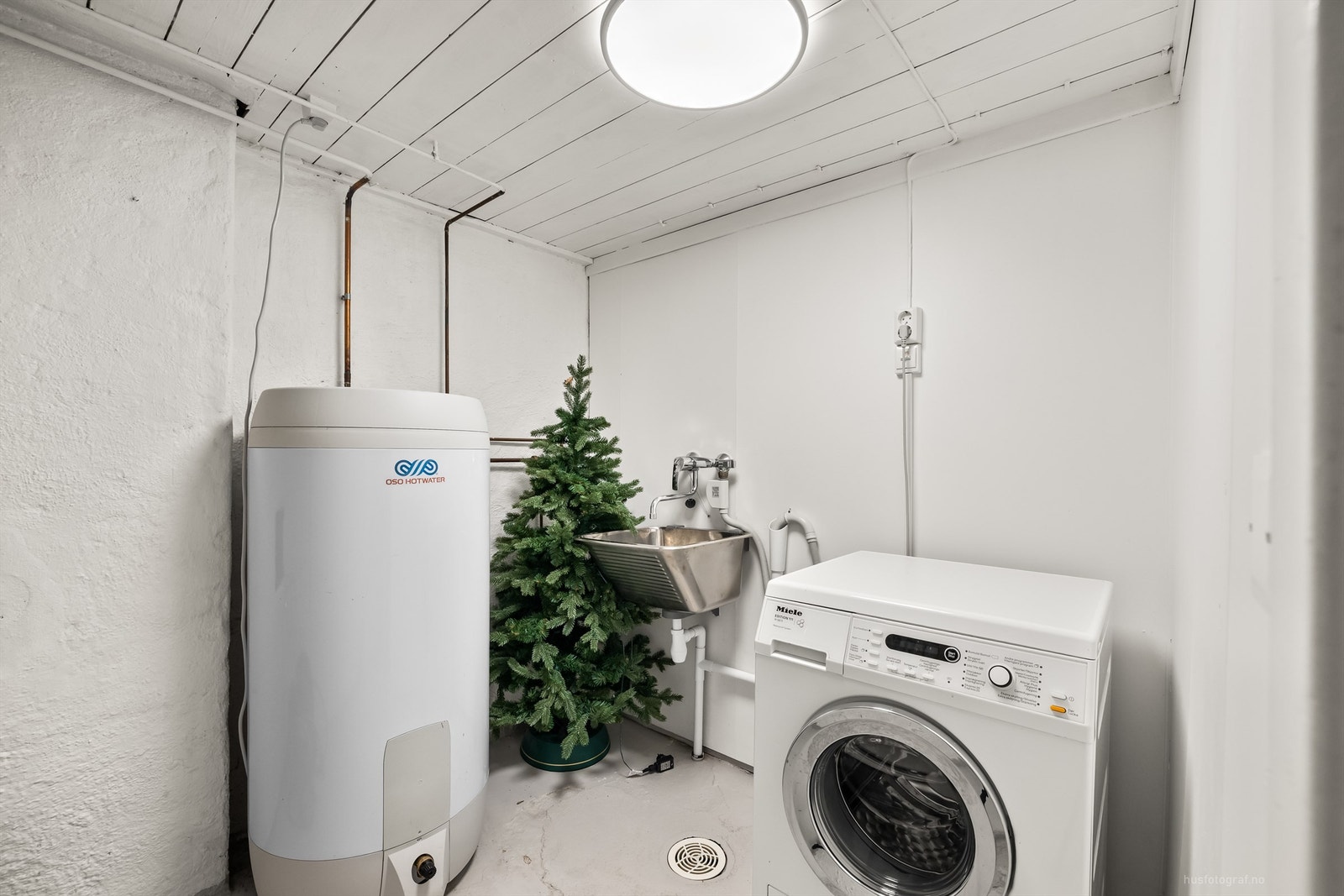 Separat vaskerom i kjelleren med opplegg for vaskemaskin og en varmtvannsbereder fra 2021. Galleribilde