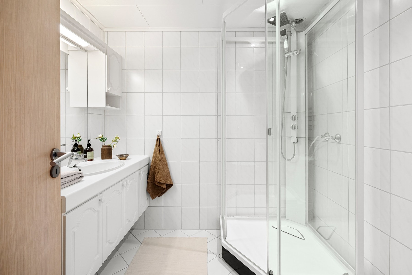 Badet i første etasje har en klassisk og funksjonell utforming, med flislagte overflater og varmekabler i gulv. Galleribilde