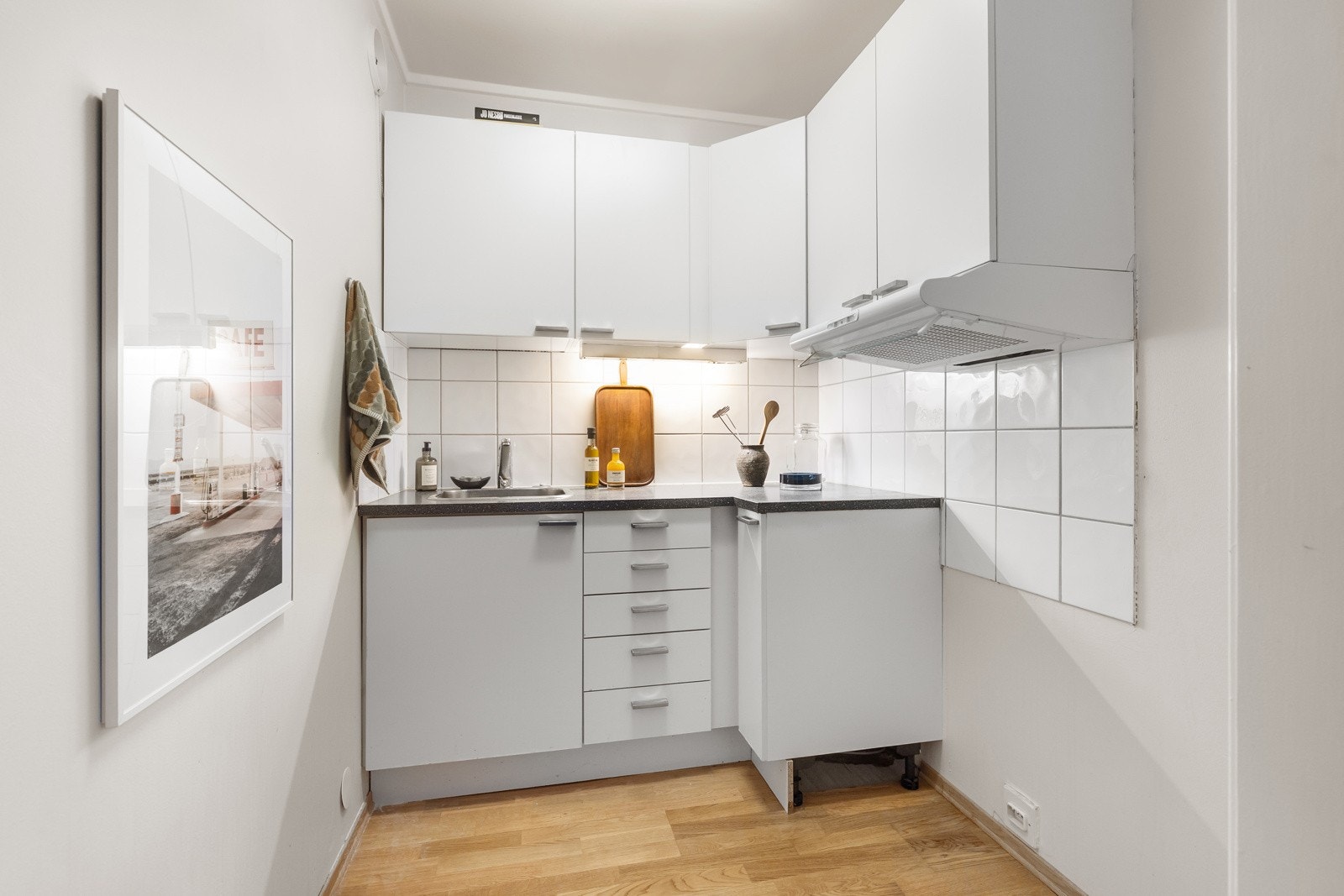 KjøkkenInnredning med glatte fronter. Laminat benkeplate med en tykkelse på 28mm. Ventilator med omluftfunksjon/kullfilter i kombinasjon med naturlig ventilering Galleribilde