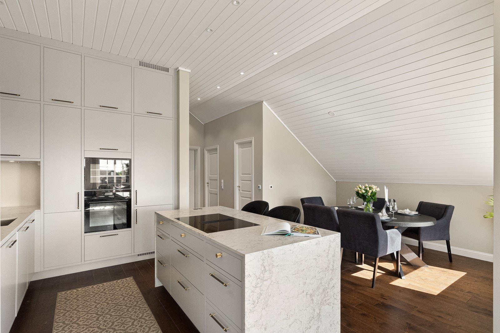 Leiligheten har en stor og åpen kjøkkenløsning mot stuen med en meget lekker, takhøy kjøkkeninnredning levert av kvalitetsleverandøren HTH i 2023. Galleribilde