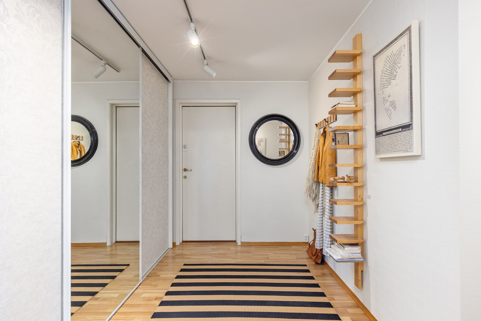 Romslig entré med stor skyvedørsgarderobe som strekker seg langs den ene veggen Galleribilde